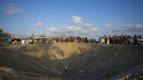 Ciudadanos palestinos observan la destrucción de un campamento de refugiados desplazados por la guerra en la Franja de Gaza después de un ataque aéreo israelí este martes 10 de septiembre, en el que asesinó al menos a 40 personas.  - Sputnik Mundo