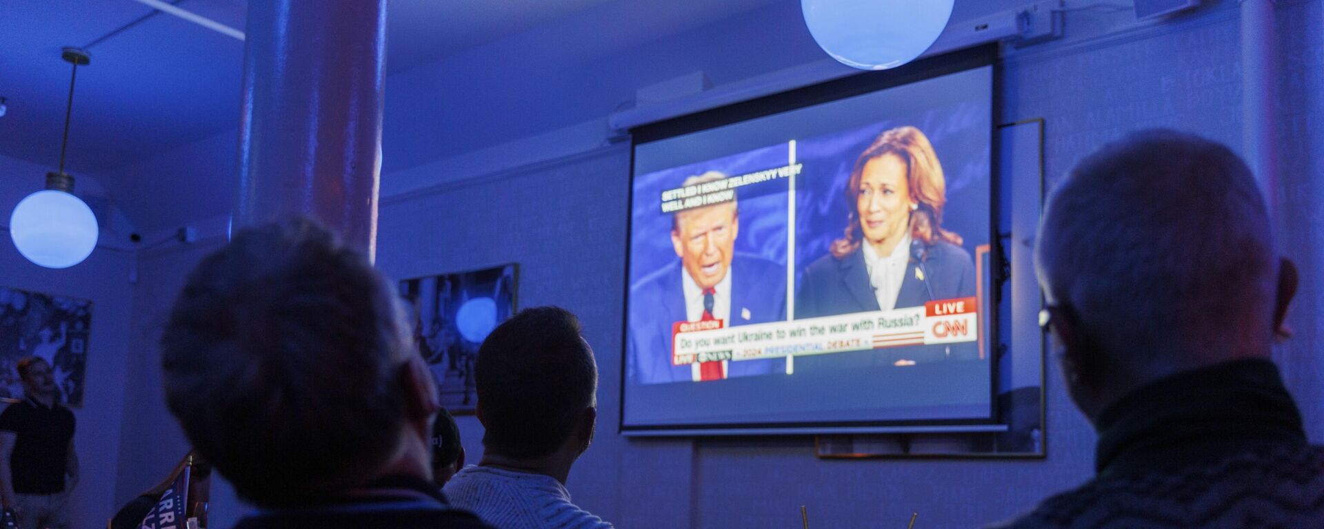 La gente mira debate presidencial entre el candidato presidencial republicano, el expresidente Donald Trump, y la candidata presidencial demócrata, la vicepresidenta Kamala Harris, en una fiesta organizada, el 10 de septiembre de 2024, en San Francisco - Sputnik Mundo, 1920, 18.09.2024