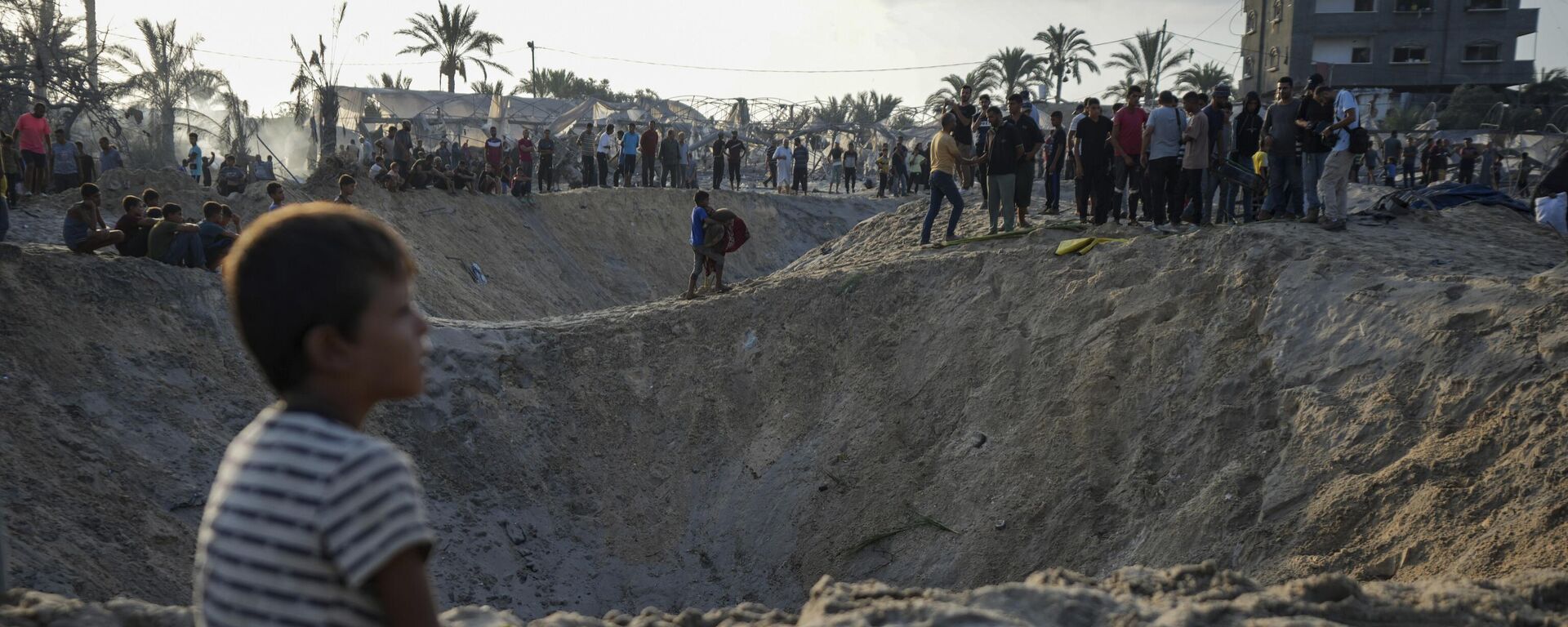 Palestinos observan la destrucción tras un ataque aéreo israelí contra un campamento de tiendas de campaña, Palestina - Sputnik Mundo, 1920, 07.10.2024