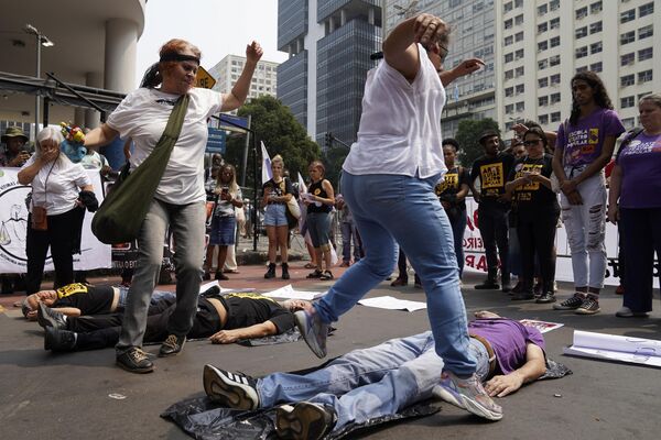 Un grupo de personas escenifica la violencia estatal durante la marcha Grito de los excluidos, que se celebra en el Día de la Independencia de Brasil, con el fin de instar a las autoridades a buscar la justicia social y tomar medidas para hacer frente al cambio climático, en Río de Janeiro. - Sputnik Mundo