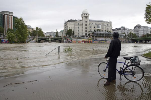 Una persona murió en el estado de Baja Austria, limítrofe con Viena, a causa de catástrofe natural. Se prevé que las fuertes lluvias continúen durante varios días más y que nieve en algunas partes del país.En la foto: un ciclista observa el derrame del canal del Danubio cerca del Observatorio Urania, en el centro de Viena, Austria. - Sputnik Mundo