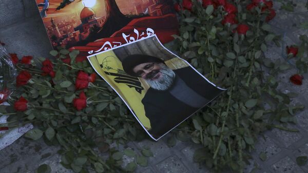 Un cartel del líder de Hizbulá, Sayed Hasán Nasralá, colocado sobre flores frente a la embajada libanesa en Teherán, Irán, el 18 de septiembre de 2024 - Sputnik Mundo