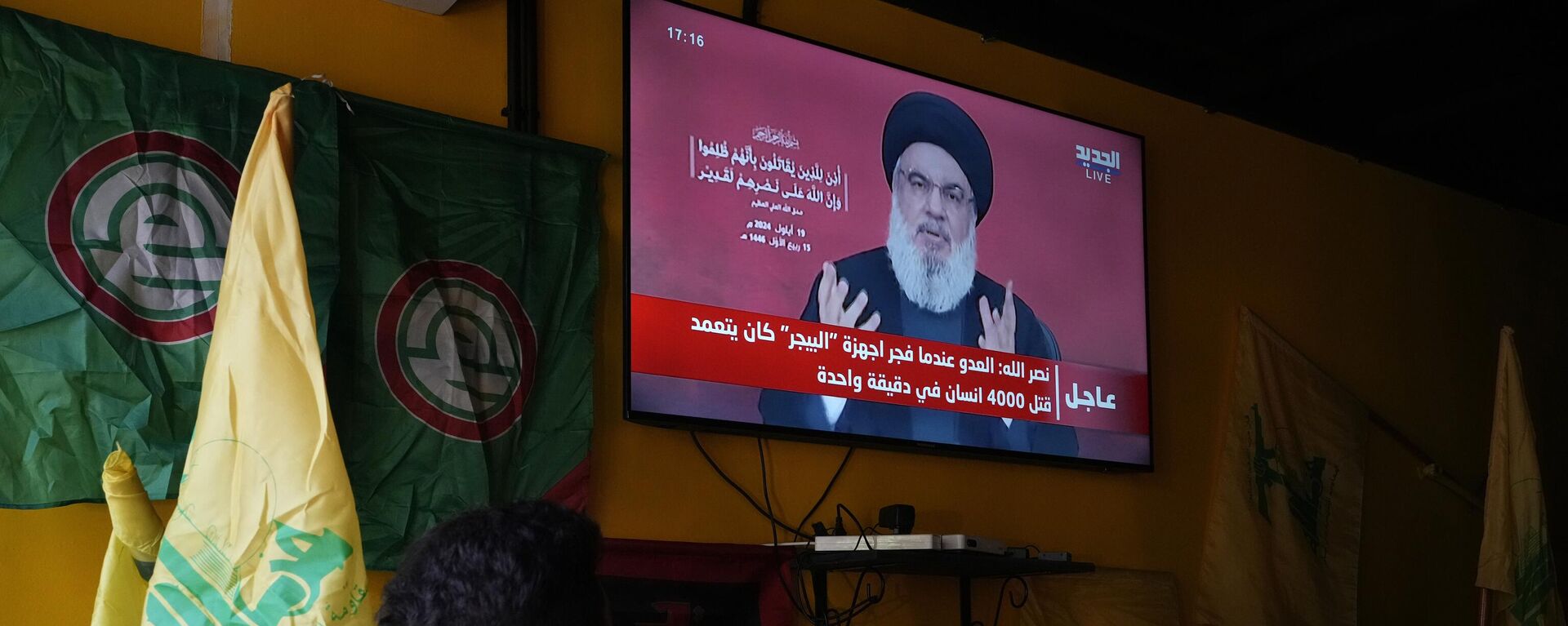 Varias personas observan el discurso del líder de Hizbulá, Hasán Nasralá, sentadas en una cafetería de los suburbios del sur de Beirut, el jueves 19 de septiembre de 2024 - Sputnik Mundo, 1920, 19.09.2024