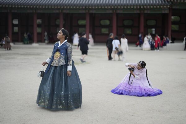 Jóvenes vestidos con el traje tradicional surcoreano hanbok, hacen fotos cerca del Palacio Gyeongbokgung, uno de los lugares más conocidos de Corea del Sur, durante el festival de Chuseok, la versión coreana del Día de Acción de Gracias, en Seúl. - Sputnik Mundo