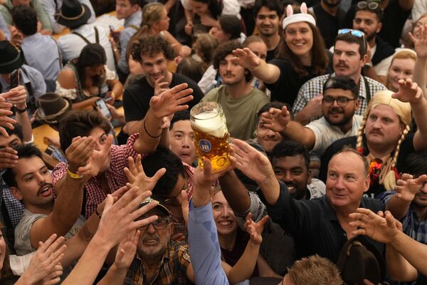 Los visitantes toman los primeros vasos de cerveza durante el primer día de la 189 edición Oktoberfest. - Sputnik Mundo