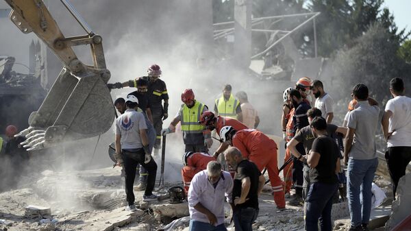 Trabajadores de emergencia buscan sobrevivientes en el lugar de un ataque aéreo israelí en la ciudad de Maisara, al norte de .. (Foto AP/Bilal Hussein) - Sputnik Mundo