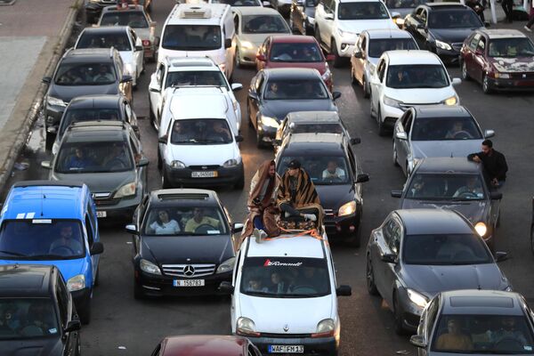 Ciudadanos libaneses que huyeron de las aldeas del sur en medio de los continuos ataques aéreos israelíes del 23 de septiembre, se sientan en sus automóviles en una autopista que conecta con la ciudad de Beirut, en la ciudad portuaria meridional de Sidón, Líbano. - Sputnik Mundo