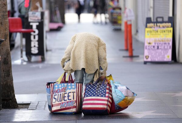 Una mujer lleva sus maletas por el Paseo de la Fama de Hollywood, en Los Ángeles. - Sputnik Mundo