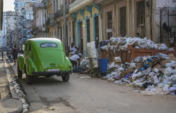 Un automóvil clásico americano pasa junto a la basura en La Habana, Cuba. - Sputnik Mundo