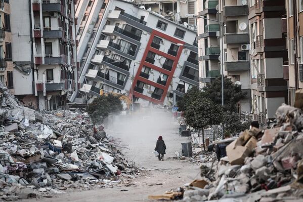 Soledad entre las ruinas, del artista Sedat Suna, que obtuvo el segundo puesto en la categoría de Documental y Fotoperiodismo.Tras el fuerte terremoto de febrero de 2023 en Hatay, Turquía, una mujer pasa junto a un edificio derrumbado. El sismo, de magnitud 7,8, causó una devastación generalizada, cobrándose más de 50.000 vidas. - Sputnik Mundo