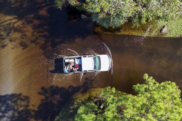 Los evacuados empiezan poco a poco a regresar a sus viviendas.En la foto: gente viajando en automóvil por la ruta inundada de regreso a Palm Harbor. - Sputnik Mundo