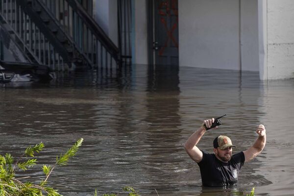 Un miembro de equipos de rescate pasa por una zona residencial anegada en la ciudad de Clearwater. - Sputnik Mundo