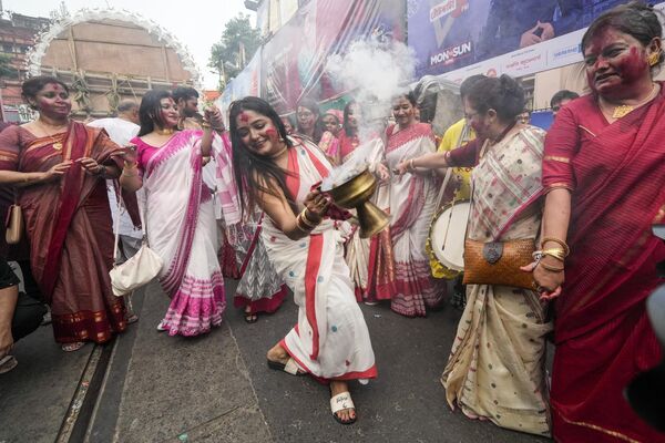 Mujeres bailan durante las celebraciones mientras participan en una procesión con motivo del último día del festival Durgá Puyá antes de que el ídolo sea sumergido en el río Hugli en la ciudad india de Calcuta. - Sputnik Mundo