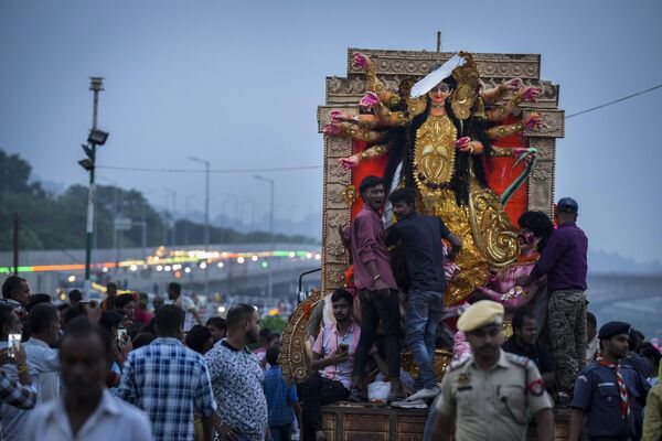 La transportación de los ídolos de la diosa Durga en un vehículo para su inmersión en el río Brahmaputra en el último día del festival Durgá Puyá en Guwahati. - Sputnik Mundo