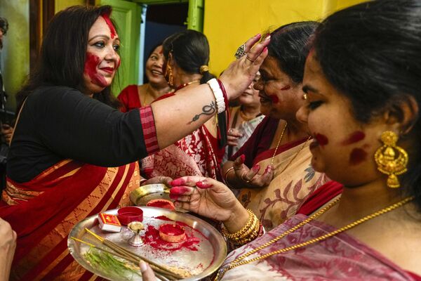 Mujeres casadas se ponen bermellón como ritual antes de la inmersión de un ídolo de la diosa hindú Durga en el río Hugli en Calcuta. - Sputnik Mundo