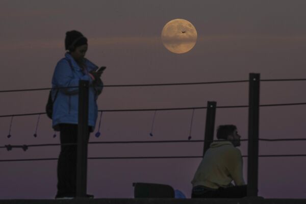 Al llegar la Superluna, se le puede observar a lo largo de toda la noche. Un cielo despejado es la clave para ver los detalles de este fenómeno no solo con un telescopio, sino también con prismáticosEn la foto: la Superluna en el lago Michigan, EEUU. - Sputnik Mundo