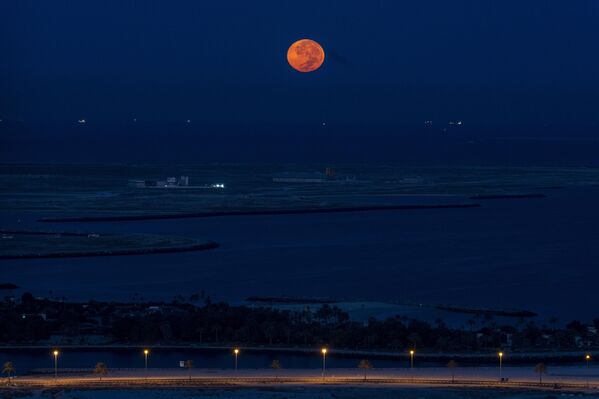 La imagen capta la noche de la Superluna sobre el golfo Pérsico al amanecer en Dubai, Emiratos Árabes Unidos. - Sputnik Mundo