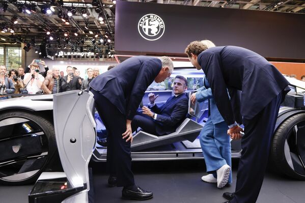 El presidente francés, Emmanuel Macron, sentado en un concept car Peugeot Inception durante su visita al stand de Stellantis en el Salón del Automóvil de París. - Sputnik Mundo