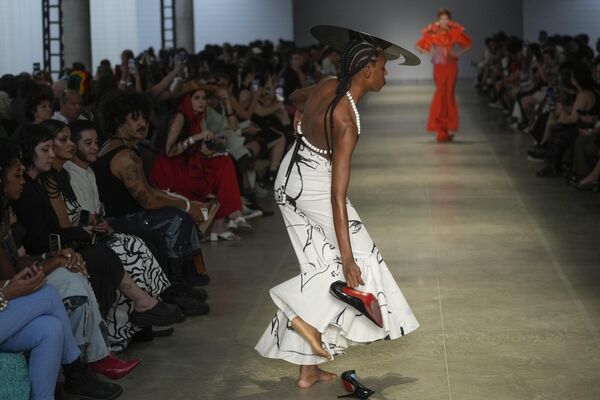 Una modelo se quita los zapatos en la pasarela durante la presentación de la colección Cria Costura en la Semana de la Moda de Sao Paulo, Brasil. - Sputnik Mundo