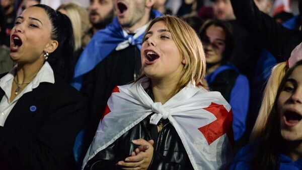 Simpatizantes del partido gobernante Sueño Georgiano celebran la victoria del partido en las elecciones parlamentarias en una plaza frente a la oficina de Sueño Georgiano en Tiflis, capital de Georgia. - Sputnik Mundo