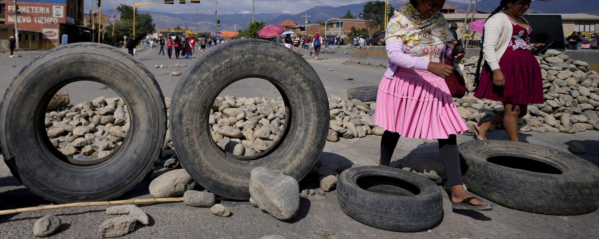 Unas mujeres pasan junto a una barricada de escombros levantada por los partidarios del expresidente Evo Morales, que bloquean las carreteras, el 28 de octubre de 2024 - Sputnik Mundo, 1920, 01.11.2024