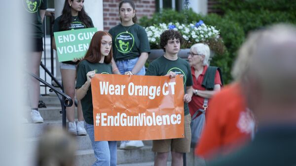 Miembros de Junior Newtown Action Alliance sostienen carteles durante una manifestación contra los tiroteos en Estados Unidos (imagen referencial) - Sputnik Mundo