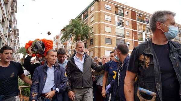 Felipe VI y Carlos Mazón (detrás) caminan por las calles de Paiporta - Sputnik Mundo