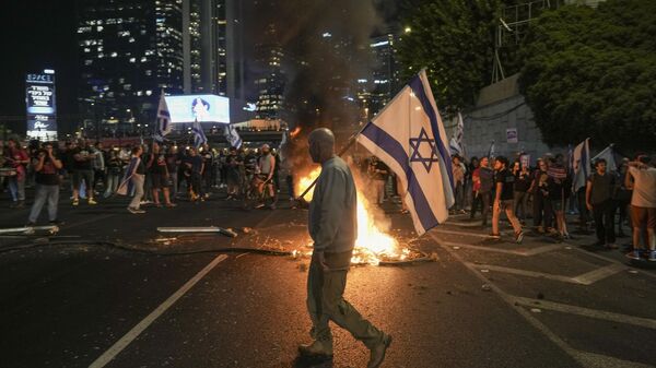 Los israelíes encienden una hoguera durante una protesta después de que el primer ministro Benjamín Netanyahu destituyera a su popular ministro de Defensa, Yoav Gallant, en Tel Aviv, Israel, el martes 5 de noviembre de 2024. (Foto AP/Oded Balilty) - Sputnik Mundo