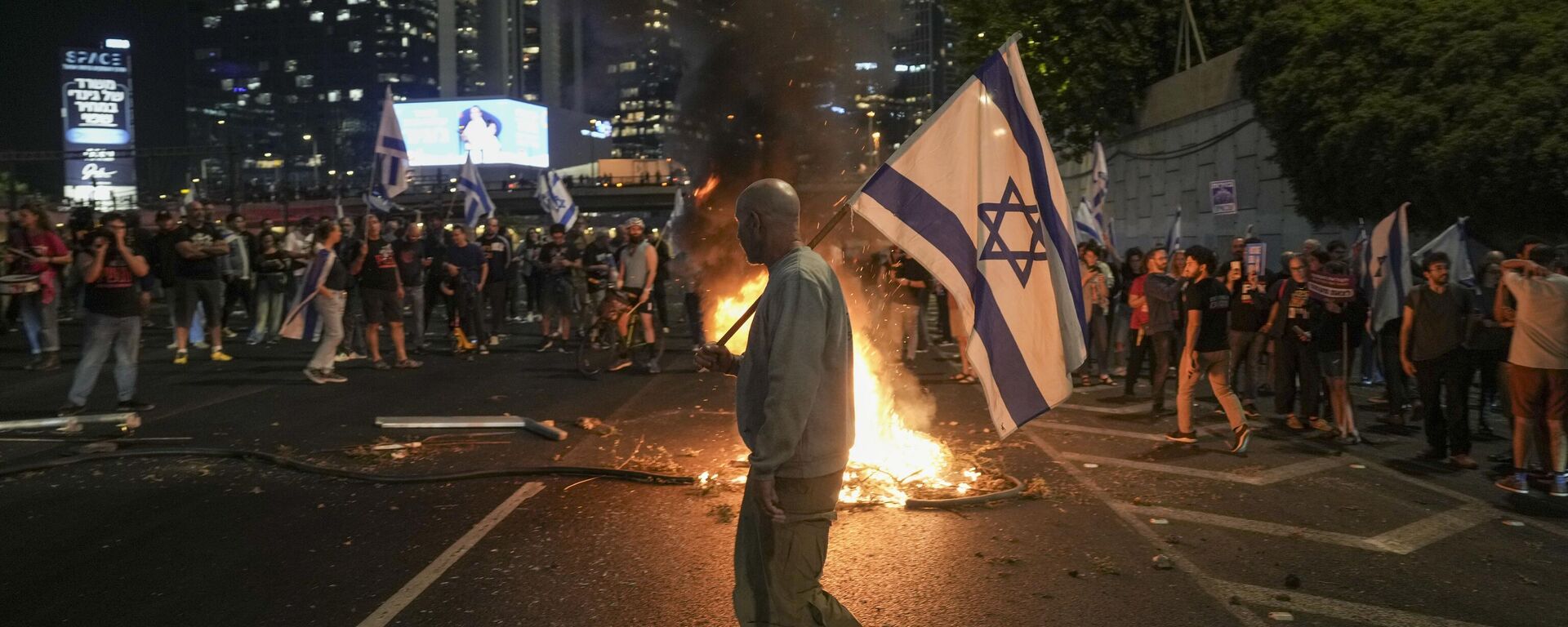 Los israelíes encienden una hoguera durante una protesta después de que el primer ministro Benjamín Netanyahu destituyera a su popular ministro de Defensa, Yoav Gallant, en Tel Aviv, Israel, el martes 5 de noviembre de 2024. (Foto AP/Oded Balilty) - Sputnik Mundo, 1920, 05.11.2024