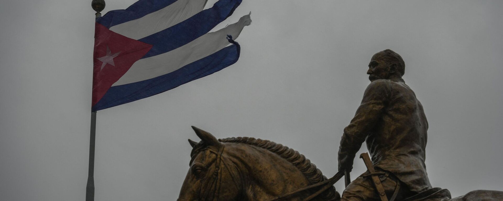 Una bandera cubana destrozada por los vientos del huracán Rafael ondea sobre la estatua del general Calixto García en La Habana, Cuba, el 6 de noviembre de 2024. - Sputnik Mundo, 1920, 09.11.2024