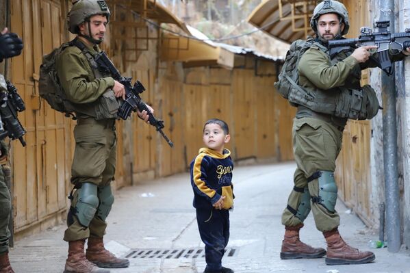 Fuerzas israelíes toman medidas de seguridad en la Ciudad Vieja durante una redada, para ofrecer protección a colonos judíos activistas que quieren visitar un lugar histórico en Hebrón, Cisjordania. - Sputnik Mundo