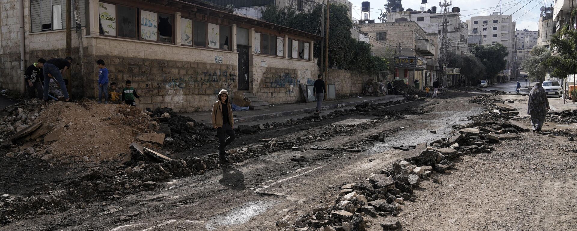 Palestinos caminan por una calle dañada durante una operación militar israelí en Cisjordania (imagen referencial) - Sputnik Mundo, 1920, 21.11.2024