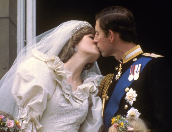 El entonces príncipe del Reino Unido, Carlos, besa a su prometida, Diana Spencer, en el balcón del palacio de Buckingham en Londres tras su boda. - Sputnik Mundo