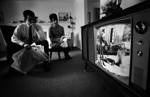 Un hombre y una mujer están viendo una película sobre la guerra de Vietnam en el salón de su casa, el 13 de febrero de 1968. - Sputnik Mundo