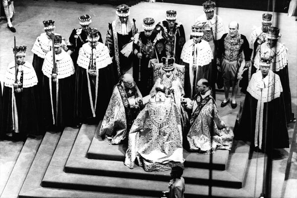 La reina Isabel II del Reino Unido, sentada en el trono, jura su cargo ante el arzobispo de Canterbury, el obispo de Durham y el obispo de Bath and Wells durante su coronación en la Abadía de Westminster. La coronación de la reina Isabel II en 1953 fue la primera coronación televisada en el Reino Unido. - Sputnik Mundo