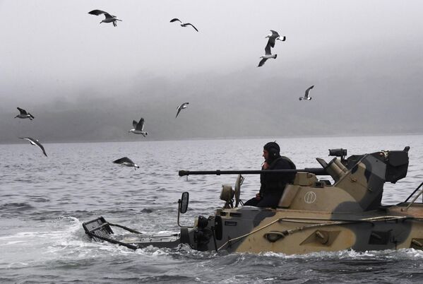 En algunos casos, los infantes de marina pueden superar por sí solos diversos obstáculos acuáticos utilizando vehículos de combate anfibios.En la foto: un efectivo en un vehículo blindado de transporte de tropas BTR-82A antes de entrar en la cubierta del gran buque de desembarco Admiral Nevelsky en Vladivostok. - Sputnik Mundo
