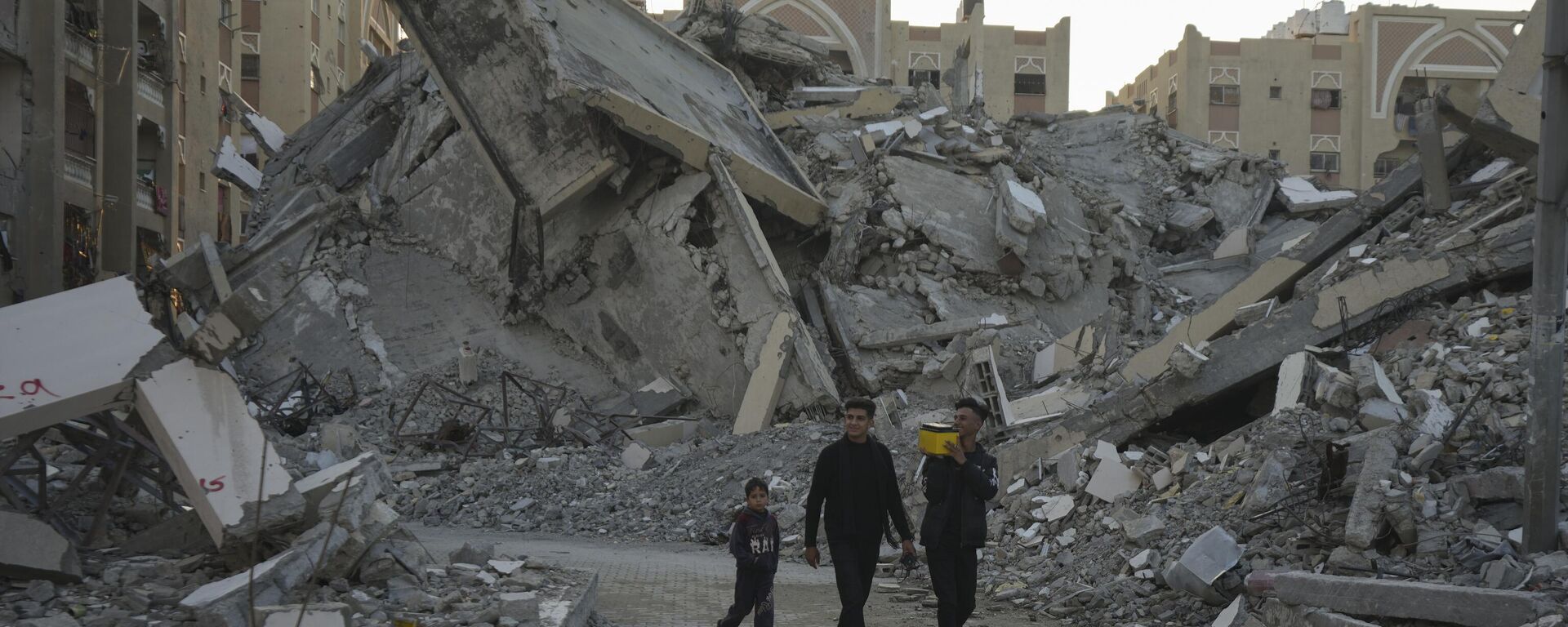 Jóvenes palestinos caminan entre los edificios destruidos por los bombardeos israelíes en un vecindario de Jan Yunis, al sur de la Franja de Gaza (imagen refrencial) - Sputnik Mundo, 1920, 02.12.2024