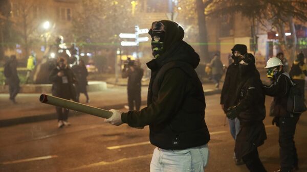 Un manifestante sostiene un petardo durante las protestas contra la decisión del Gobierno de suspender las negociaciones de adhesión a la Unión Europea en Tiflis, Georgia, el 3 de diciembre de 2024 - Sputnik Mundo