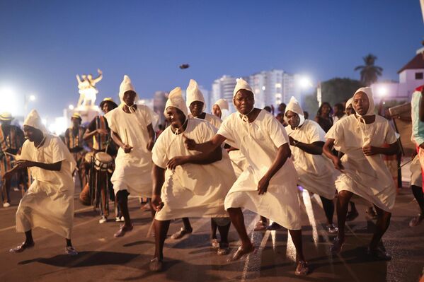 Miembros de diferentes grupos étnicos y bailarines vestidos con trajes locales caminan hacia el Gran Teatro durante el Carnaval de Dakar en la Plaza de la Independencia de Dakar, Senegal. - Sputnik Mundo