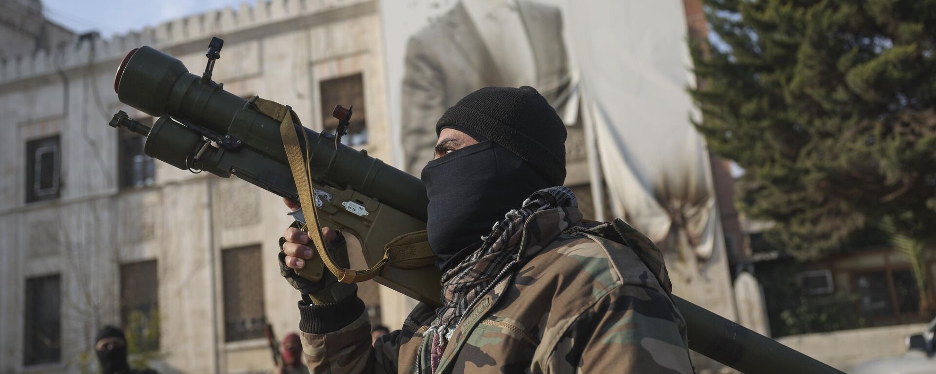 Combatientes de la oposición siria frente a la oficina del Gobierno provincial, donde una imagen del presidente sirio Bashar Asad está plagada de balas en la fachada, Hama, Siria, el 6 de diciembre de 2024 - Sputnik Mundo, 1920, 08.12.2024