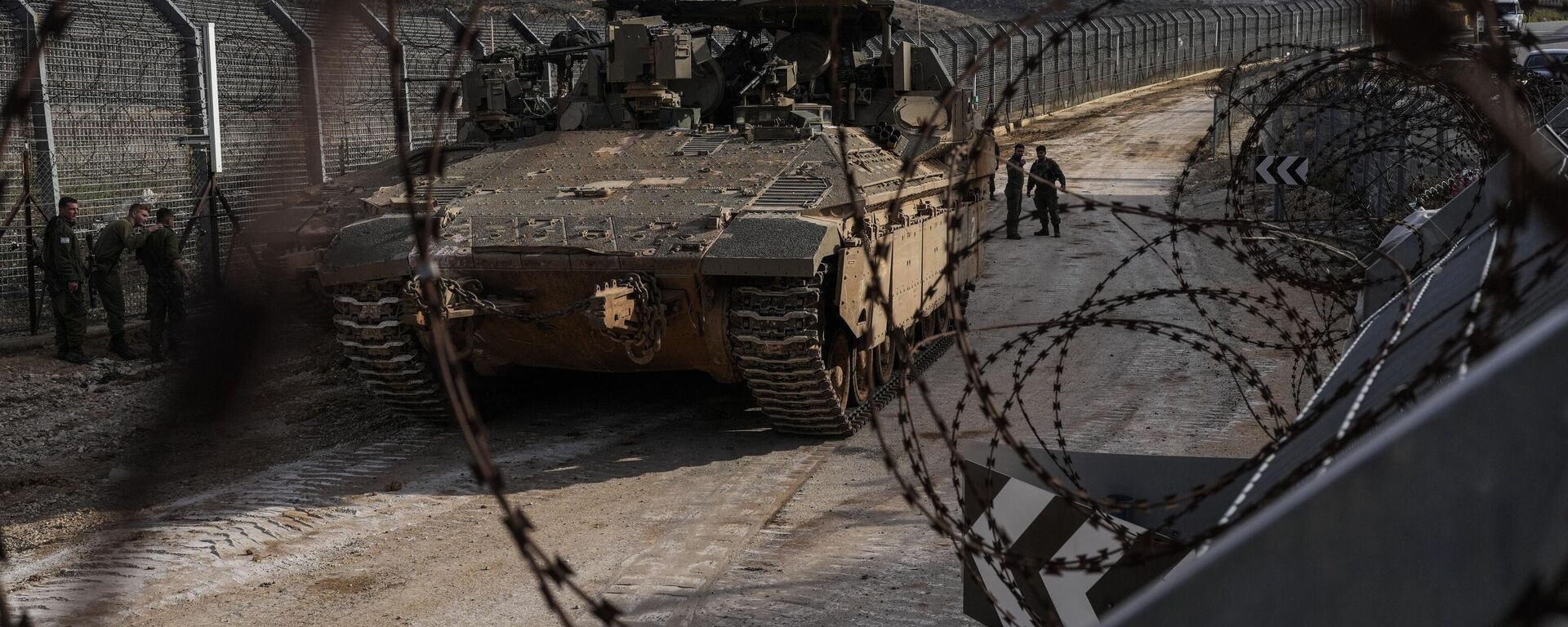 Soldados israelíes junto a vehículos blindados estacionados cerca de la llamada Línea Alfa que separa los Altos del Golán anexionados por Israel de Siria, en la localidad de Majdal Shams, el 9 de diciembre de 2024. - Sputnik Mundo, 1920, 28.01.2025