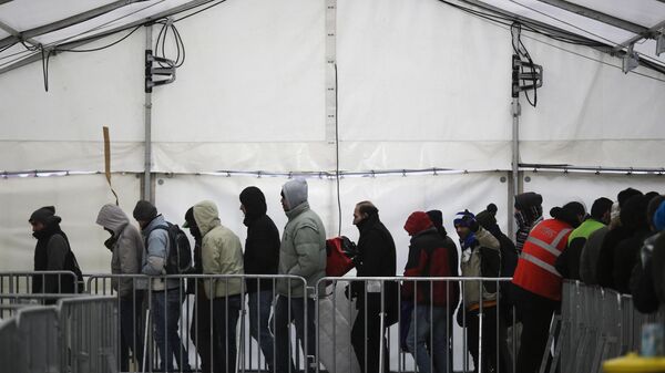 Migrantes y refugiados hacen fila en el centro de registro central para refugiados y solicitantes de asilo LaGeSo en Berlín, Alemania, el lunes 4 de enero de 2016 (imagen referencial) - Sputnik Mundo