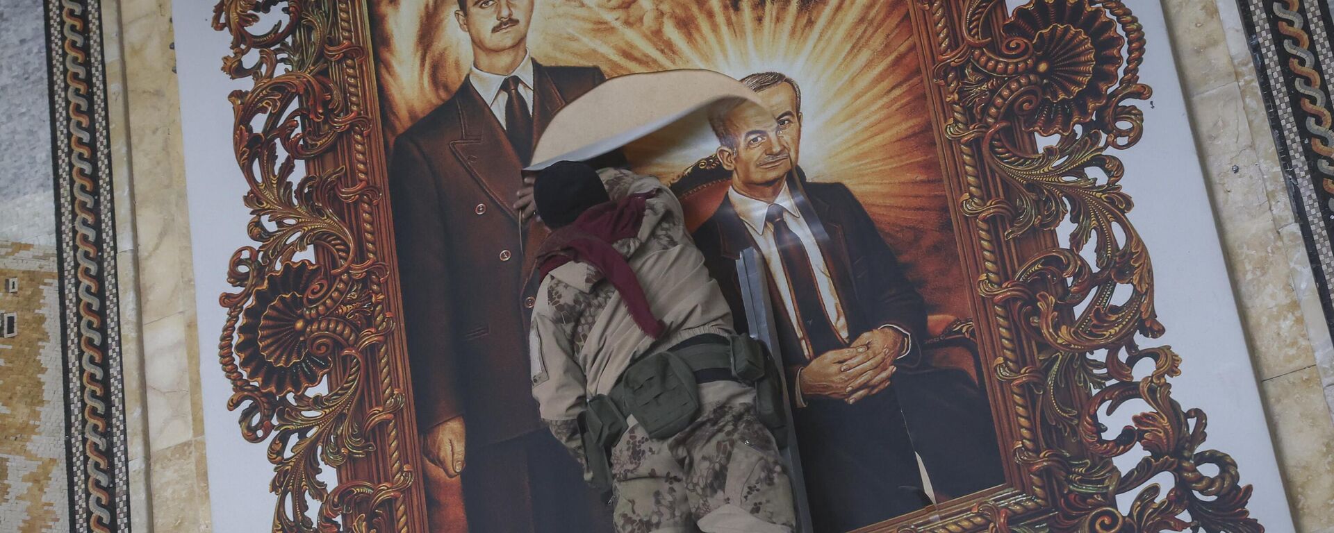 Un combatiente de la oposición siria rompe un cuadro que representa al derrocado presidente sirio Bashar Asad y a su difunto padre, Hazef Asad, en el aeropuerto internacional de Alepo, en Alepo, Siria, el 2 de diciembre de 2024 - Sputnik Mundo, 1920, 10.12.2024