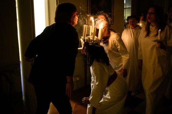 El día de Santa Lucía es una de las principales fiestas tradicionales de Suecia y otras partes de Escandinavia. Según una leyenda, en la Edad Media, la mujer de un pescador llamada Lucía fue asesinada por demonios cuando alumbraba el camino de su marido desde el muelle al apagarse el faro. En este día es costumbre organizar procesiones festivas que simbolizan la victoria de la luz y el bien sobre las fuerzas del mal.En la foto: los miembros del Coro Nórdico de Londres durante las celebraciones del Día de Santa Lucía en la capital británica. - Sputnik Mundo