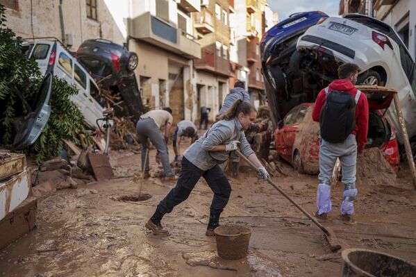 Las personas limpian una calle de barro en una zona afectada por las inundaciones en Payport, la ciudad en la región de Valencia, España, el 2 de noviembre. - Sputnik Mundo