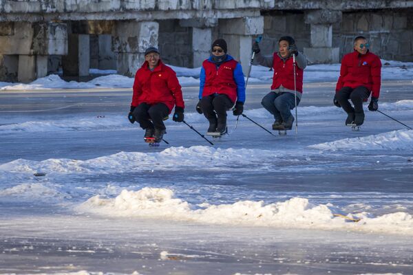Personas de edad avanzada montan burros de una sola pata, un tipo especial de trineo, en China. Los usuarios se ponen en cuclillas sobre una tabla de madera sujeta a una cuchilla de patín, o se sientan en un asiento encima de la tabla y se empujan hacia delante con dos puntas de acero. - Sputnik Mundo