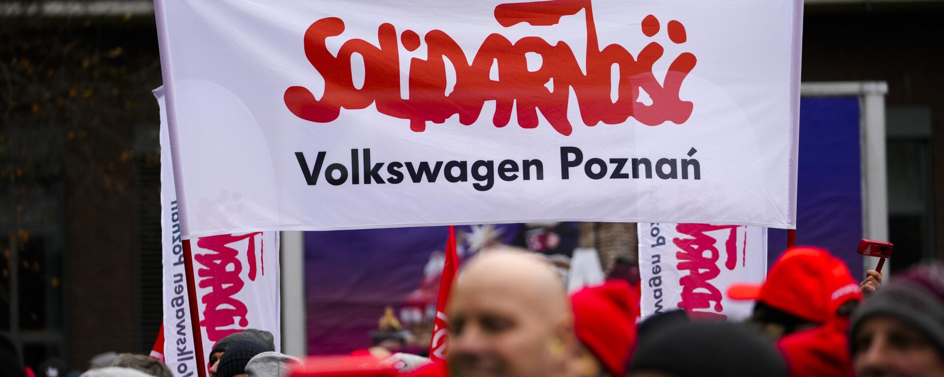 Trabajadores sostienen una pancarta con el logo del sindicato polaco Solidarnosc durante una huelga de advertencia del sindicato IG Metall, frente a la sede del fabricante de automóviles Volkswagen en Wolfsburg, Alemania, el lunes 9 de diciembre de 2024.  - Sputnik Mundo, 1920, 20.12.2024