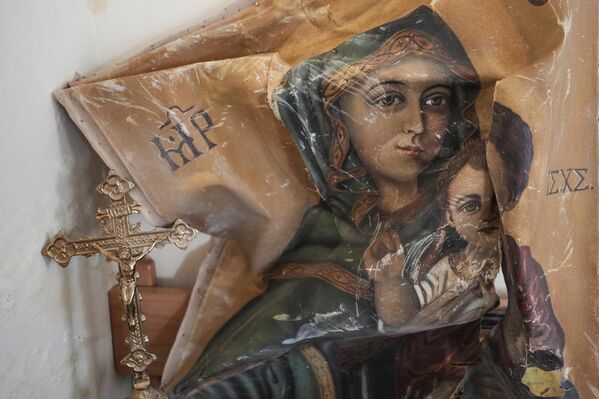 Un icono dañado y una cruz se esconden en el interior de una habitación que suele utilizarse como residencia para obispos visitantes. - Sputnik Mundo