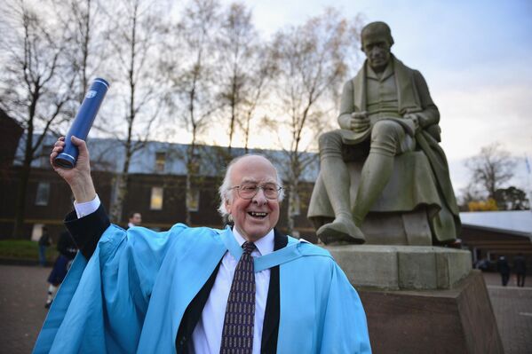 El profesor Peter Higgs, posa para las fotos delante de una estatua de James Watt después de recibir el título honorífico de doctor en Ciencias, de la Universidad Heriot-Watt, el 16 de noviembre de 2012, en Escocia.El 8 de abril, Higgs falleció en su casa a los 94 años de edad. - Sputnik Mundo