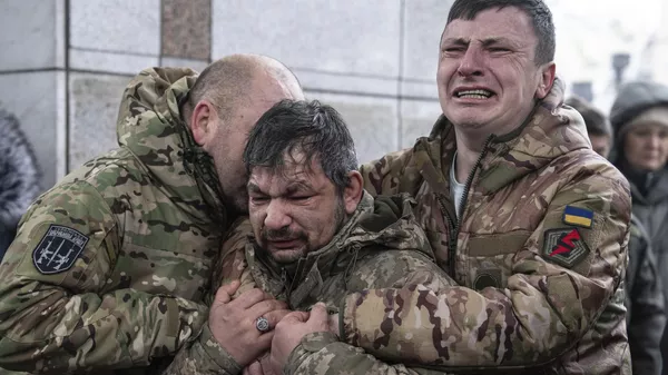 Militares ucranianos lloran junto al ataúd de su camarada en Kiev, Ucrania, el 15 de diciembre de 2023  - Sputnik Mundo